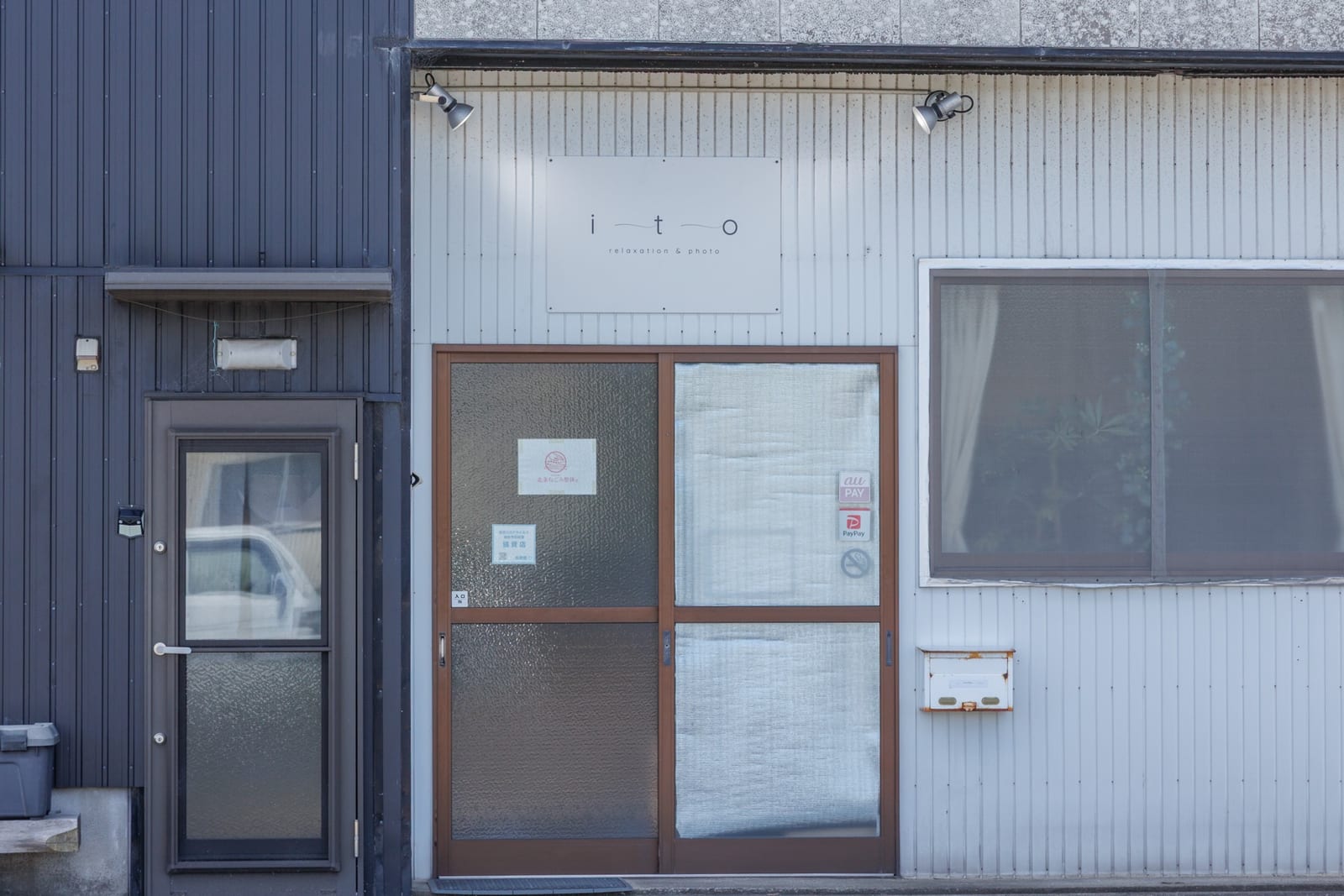 ito relaxation & photo の入口。白い外壁に ito の看板が掲げられている
