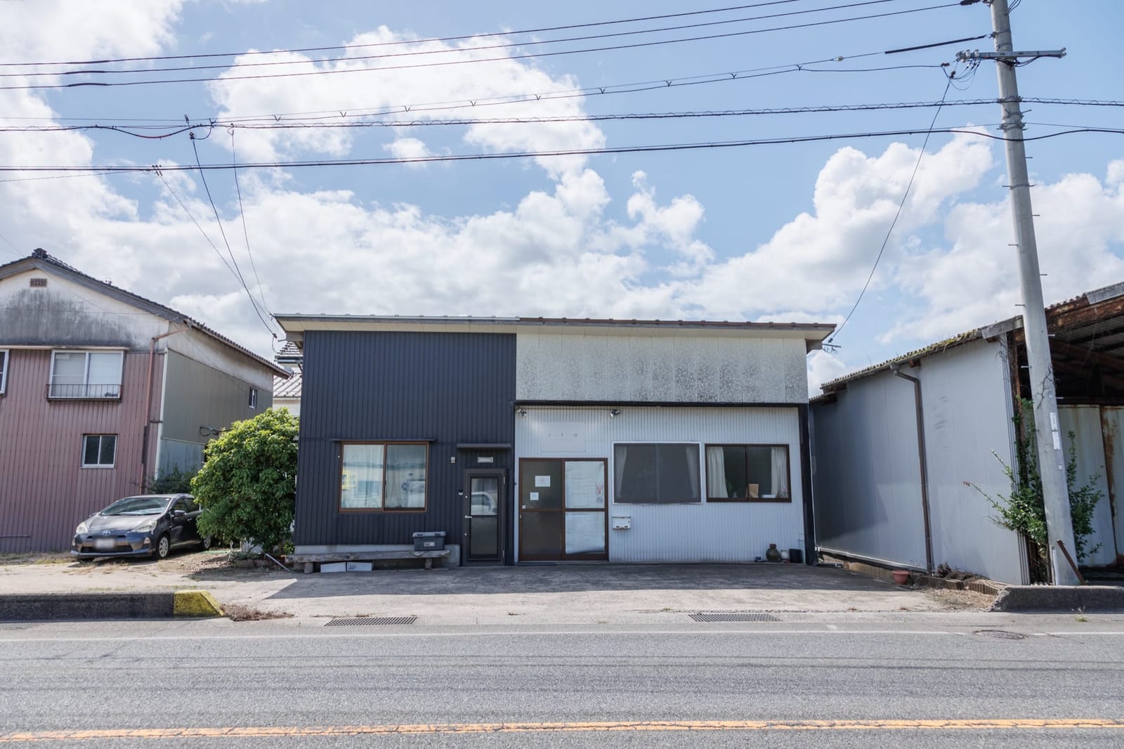青空の下に建つ ito relaxation & photo の外観と、店舗前の駐車スペース
